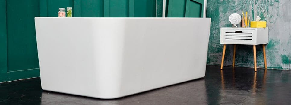 a square batutub in a gree wall tile bathroom next to a dressing cabinet a square batutub in a gree wall tile bathroom next to a dressing cabinet