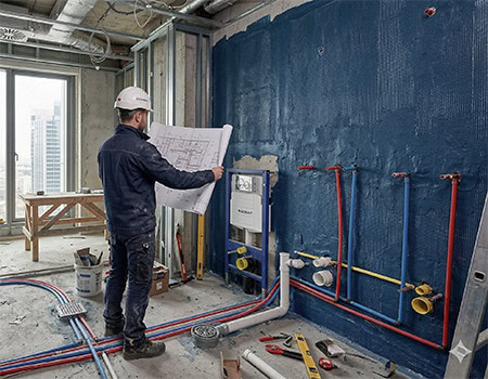 An engineer holding the drawings in a high-end hotel bathroom under construction OEM & ODM China Faucet Manufacturer