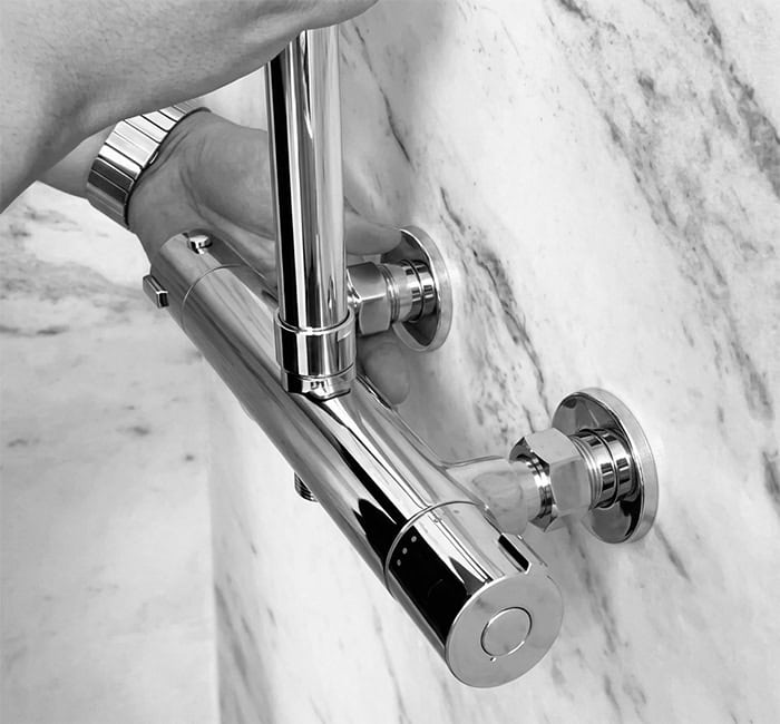 A worker is installing exposed shower system A worker is installing exposed shower system