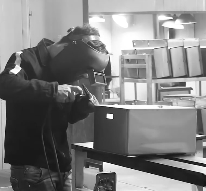 A worker is welding a kitchen sink